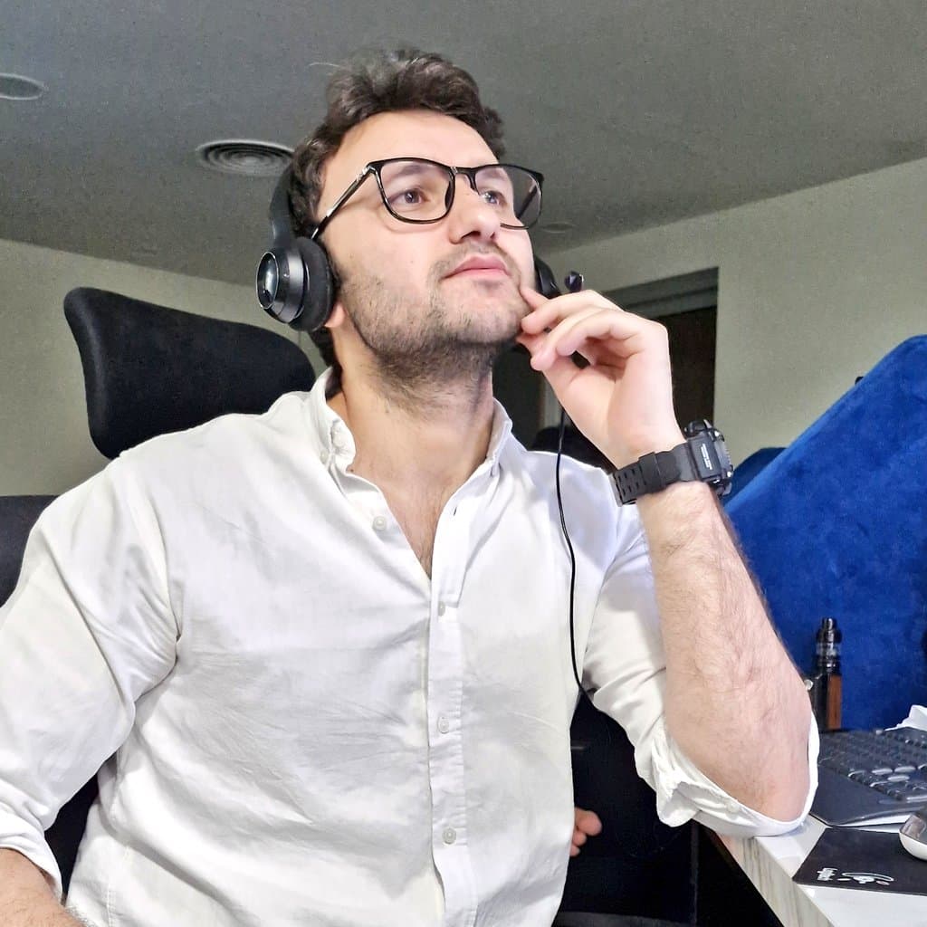 Ahmed Qureshi working at a desk with headphones on.